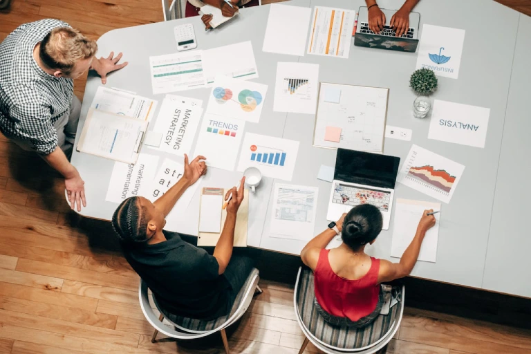 Marketing team reviewing strategy reports and analytics at a desk